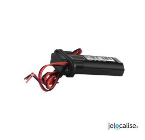 Boîtier GPS moto avec fils rouges et noir posé contre fond blanc.